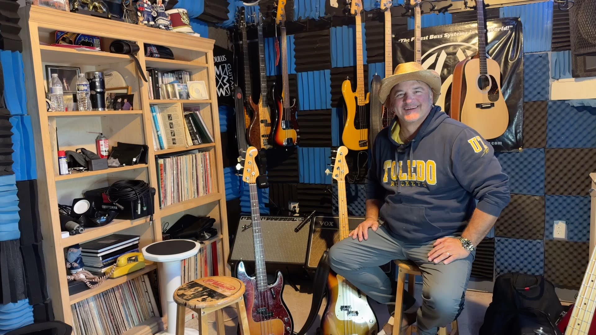Andy on a stool in the BASSment surrounded by Fender basses and amps